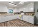 Bright kitchen with white appliances, ample counter space, tile backsplash, and modern flooring at 7310 Granada Rd, Denver, CO 80221