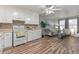 Open floorplan with kitchen and living room, featuring wood floors and bright, neutral decor at 7310 Granada Rd, Denver, CO 80221