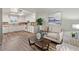 Bright living room with hardwood floors seamlessly transitioning to a kitchen area, featuring neutral-toned furniture at 7310 Granada Rd, Denver, CO 80221