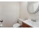 Clean half bathroom featuring a toilet, sink with wood cabinet, and a decorative mirror at 12927 W 20Th Ave, Golden, CO 80401