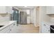 Light and bright kitchen with stainless steel refrigerator, white cabinetry, and light-colored flooring at 12927 W 20Th Ave, Golden, CO 80401