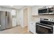 Well-lit kitchen featuring stainless steel appliances, white cabinets, and light wood-look flooring at 12927 W 20Th Ave, Golden, CO 80401