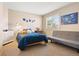 Bright bedroom with a blue bed, a daybed, a white dresser, and light neutral walls for a calming space at 12710 W 84Th Cir, Arvada, CO 80005
