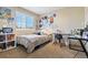 Bedroom with posters and a desk alongside a black cushioned chair and a display cabinet with a shelf at 12710 W 84Th Cir, Arvada, CO 80005