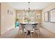 Dining room with modern chandelier, round table, stylish chairs, and natural light from the window at 12710 W 84Th Cir, Arvada, CO 80005