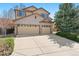 Exterior view of a brick and siding two-story home with a spacious three-car garage at 12710 W 84Th Cir, Arvada, CO 80005