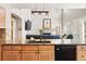 Open kitchen with granite countertops, wooden cabinets, stainless steel appliances, and a view to the living room at 12710 W 84Th Cir, Arvada, CO 80005