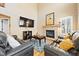 Inviting living room featuring a fireplace, mounted TV, comfortable sofas, and stylish decor at 12710 W 84Th Cir, Arvada, CO 80005