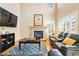 Cozy living room features a fireplace, TV, plush sofas, and large windows with natural light at 12710 W 84Th Cir, Arvada, CO 80005