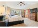 This is a comfortable main bedroom with a rustic dresser, a bay window, and barn doors to the bathroom at 12710 W 84Th Cir, Arvada, CO 80005