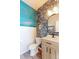 Stylish powder room featuring patterned wallpaper, decorative lighting and a contemporary vanity at 5156 Bittercress Rd, Brighton, CO 80640