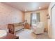 Charming Bedroom with crib, glider, and soft colors, creating a sweet space for new beginnings at 5156 Bittercress Rd, Brighton, CO 80640