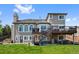 Back of the home featuring a two-story deck and a large grassy yard at 7056 S Owens St, Littleton, CO 80127