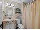 Charming bathroom featuring a decorative vanity with sink, a toilet, and a shower with curtain at 7056 S Owens St, Littleton, CO 80127