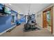 Exercise room in basement with a television, blue accent wall, and full equipment at 7056 S Owens St, Littleton, CO 80127