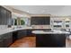 Well-lit kitchen with dark cabinets, a center island cooktop, and plenty of counter space at 7056 S Owens St, Littleton, CO 80127