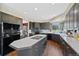 Spacious kitchen featuring a center island with cooktop and plentiful dark wood cabinetry at 7056 S Owens St, Littleton, CO 80127