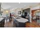 Open kitchen featuring an island cooktop, adjacent dining, and seamless flow into the living area at 7056 S Owens St, Littleton, CO 80127