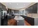 Spacious kitchen featuring a center island with cooktop and plentiful dark wood cabinetry at 7056 S Owens St, Littleton, CO 80127