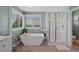 Spa-like bathroom with modern tub, glass shower, and natural light streaming through plantation shutters at 7056 S Owens St, Littleton, CO 80127