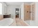 Bright bathroom featuring dual sinks, a soaking tub, and a separate shower at 14920 Munich Ave, Parker, CO 80134