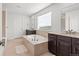Large bathroom featuring dual sinks, a soaking tub, and a separate shower at 14920 Munich Ave, Parker, CO 80134