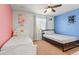 Bright bedroom featuring two beds, a ceiling fan, and colorful accent walls at 14920 Munich Ave, Parker, CO 80134