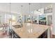 Large kitchen island with granite countertops and stainless steel sink, open to the living room at 14920 Munich Ave, Parker, CO 80134