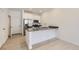 Modern kitchen featuring a breakfast bar, stainless steel appliances, white cabinetry, and laminate flooring at 2006 S Haleyville Way, Aurora, CO 80018