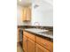 Close-up of a kitchen sink featuring a granite countertop and wooden cabinetry with a stainless steel faucet at 300 W 11Th Ave # 6G, Denver, CO 80204