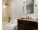 Bathroom with a tiled shower/tub combo, a dark vanity, and bronze fixtures at 2153 S Columbine St, Denver, CO 80210