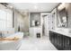 Bright bathroom with double vanity, soaking tub, and glass-enclosed shower with marble tile at 2153 S Columbine St, Denver, CO 80210