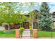 Charming red brick home with manicured lawn and garden beds, partially obscured by mature trees at 2153 S Columbine St, Denver, CO 80210