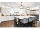 Modern kitchen features white cabinetry, stainless steel appliances, and a large island with counter seating at 2153 S Columbine St, Denver, CO 80210