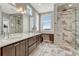 Bright bathroom with a double sink vanity, luxurious marble shower, and contemporary design elements at 9796 Bennett Peak St, Littleton, CO 80125