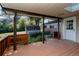 Covered back porch with wooden deck, offering a view of the lush backyard and storage shed at 1475 S Urban Way, Lakewood, CO 80228