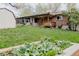 Spacious backyard featuring a well-maintained lawn, mature trees, and garden box at 1475 S Urban Way, Lakewood, CO 80228