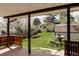 View from covered back porch of fenced yard with grass, shed, and fountain at 1475 S Urban Way, Lakewood, CO 80228
