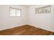 A serene bedroom featuring warm hardwood floors and ample natural light from two large windows at 1475 S Urban Way, Lakewood, CO 80228