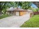 A charming brick home with a long driveway, detached garage, and a well-maintained yard at 1475 S Urban Way, Lakewood, CO 80228
