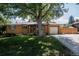 Charming brick home featuring a well-manicured lawn, mature shade tree, and inviting curb appeal at 1475 S Urban Way, Lakewood, CO 80228