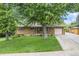 Traditional brick home with mature landscaping, a well-manicured lawn, and a front-facing garage at 1475 S Urban Way, Lakewood, CO 80228