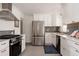 Beautiful kitchen equipped with stainless steel appliances, white cabinets, stylish backsplash, and ample counter space at 1475 S Urban Way, Lakewood, CO 80228