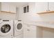 A bright laundry room complete with updated appliances, countertop space, and clean white cabinets at 1475 S Urban Way, Lakewood, CO 80228