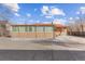 Brick home exterior with enclosed sunroom and expansive concrete patio area at 1275 Otis St, Lakewood, CO 80214