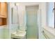 Retro bathroom with light-green tiled walls, classic sink, and a glass-enclosed shower stall at 1275 Otis St, Lakewood, CO 80214