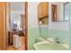Retro-style bathroom with classic green tiling, a modern toilet, and an open view to the bedroom at 1275 Otis St, Lakewood, CO 80214