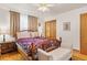 Cozy bedroom with hardwood floors, ceiling fan, wooden furnishings, and a comfortable upholstered bench at 1275 Otis St, Lakewood, CO 80214