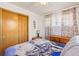 Bright bedroom features hardwood floors, wooden closet doors, patterned curtains, and matching wooden dressers at 1275 Otis St, Lakewood, CO 80214