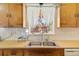 A functional kitchen sink with wooden cabinets and a view to the street at 1275 Otis St, Lakewood, CO 80214